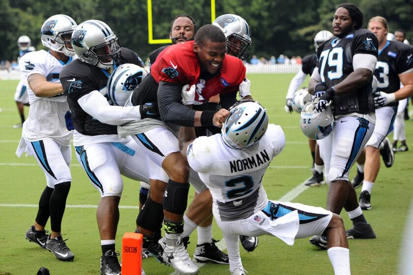 Carolina's Cam Newton (red jersey) and Josh Norman scuffle Monday during training camp at Wofford College in Spartanburg, S.C.