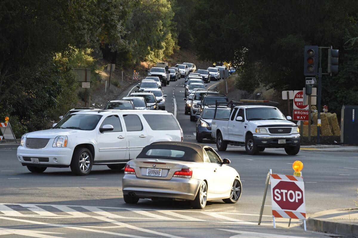 Vehicles do their best to cross the intersection of Camino Pablo and Brookwood Road during a power outage in Orinda, Calif., on Oct. 10 as the blackout would leave many homes and businesses in the dark.