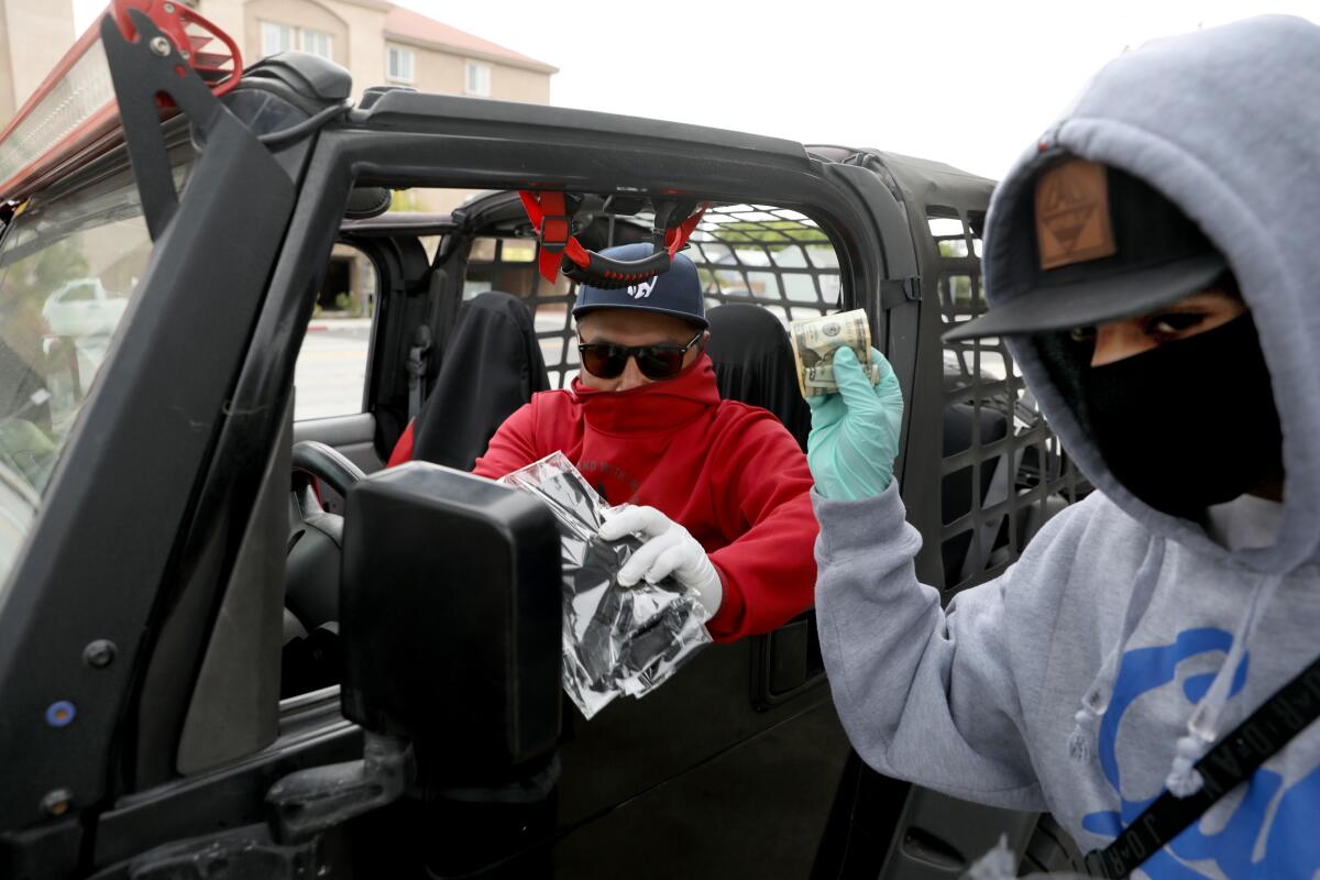 David Mendez sells a mask to Anthony Antonio on Prairie Avenue