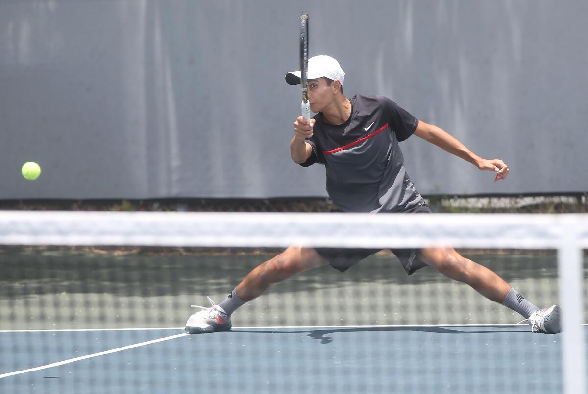 Lawee Sherif of Huntington Beach slides into a forehand return against Andy Hernandez of Fullerton in the boys' 16-and-under quarterfinals of the USTA Southern California Junior Sectional Championships at Los Caballeros Sports Village on Friday.