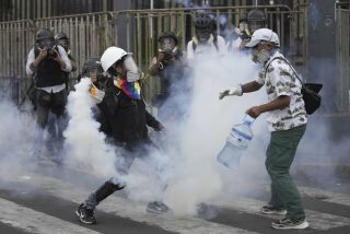 Los así llamados "desactivadores" trabajan para neutralizar un bote de gas lacrimógeno durante una protesta antigubernamental el sábado 28 de enero de 2023, en Lima, Perú. (AP Foto/Martín Mejía)