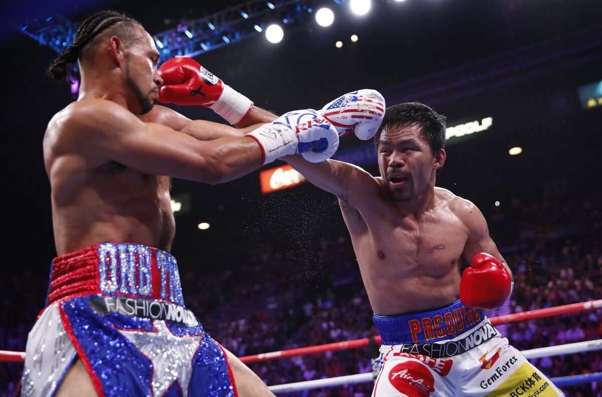 Manny Pacquiao, right, and Keith Thurman exchange punches in the second round of their welterweight title fight.