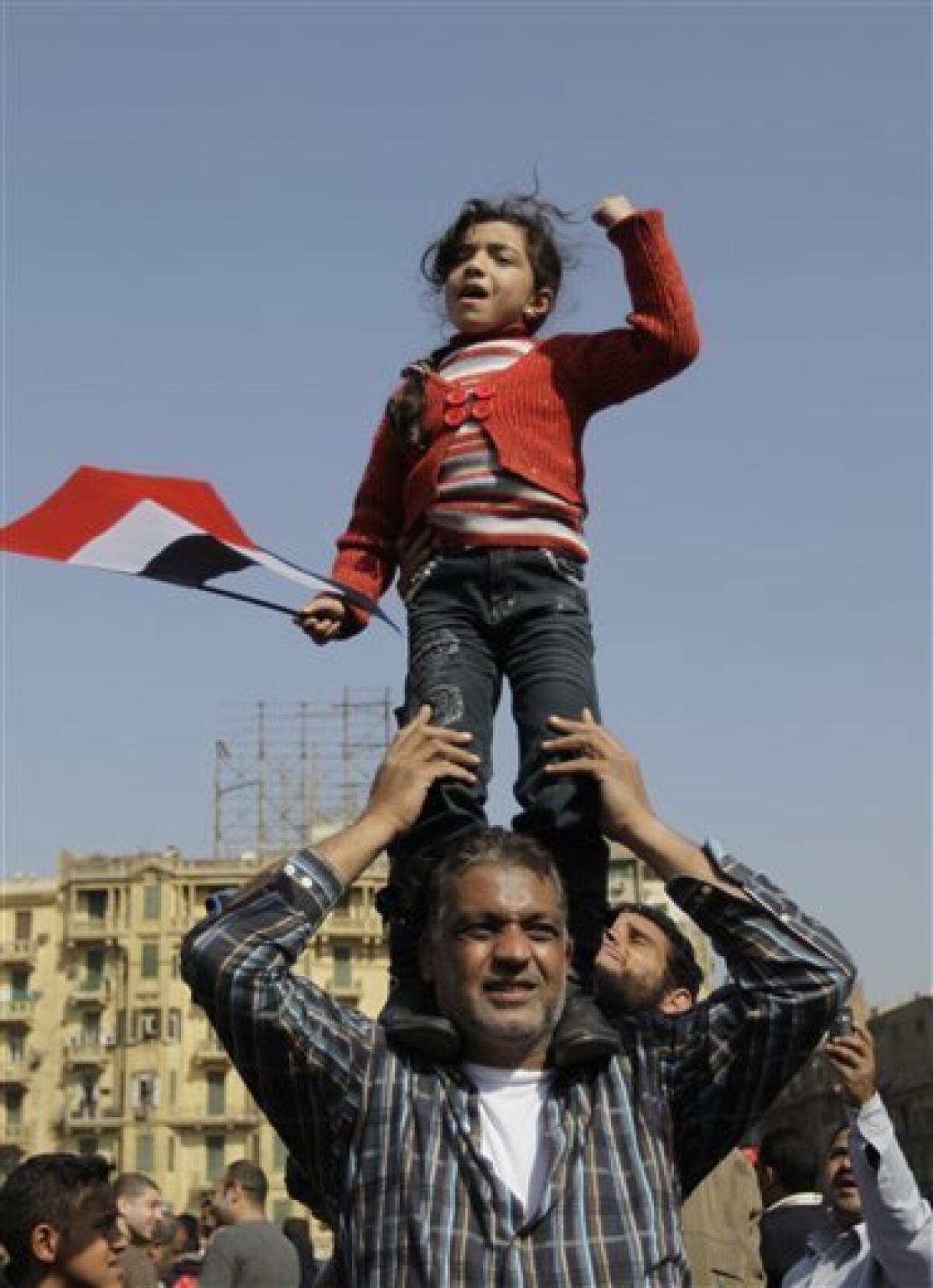 A girl standing on a man's shoulders reacts during a demonstration in Tahrir, or Liberation, Square in Cairo, Egypt, Tuesday, Feb. 1, 2011. More than a quarter-million people flooded into the heart of Cairo Tuesday, filling the city's main square in by far the largest demonstration in a week of unceasing demands for President Hosni Mubarak to leave after nearly 30 years in power. (AP Photo/Ben Curtis)