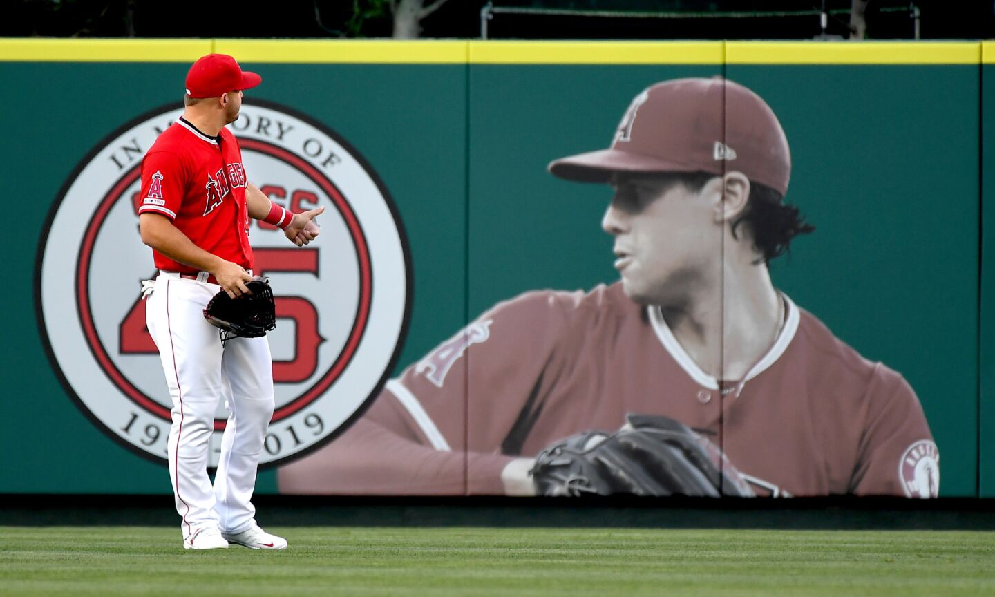 Angels center fielder Mike Trout gestures towards a memorial of pitcher pitcher Tyler Skaggs before the game.