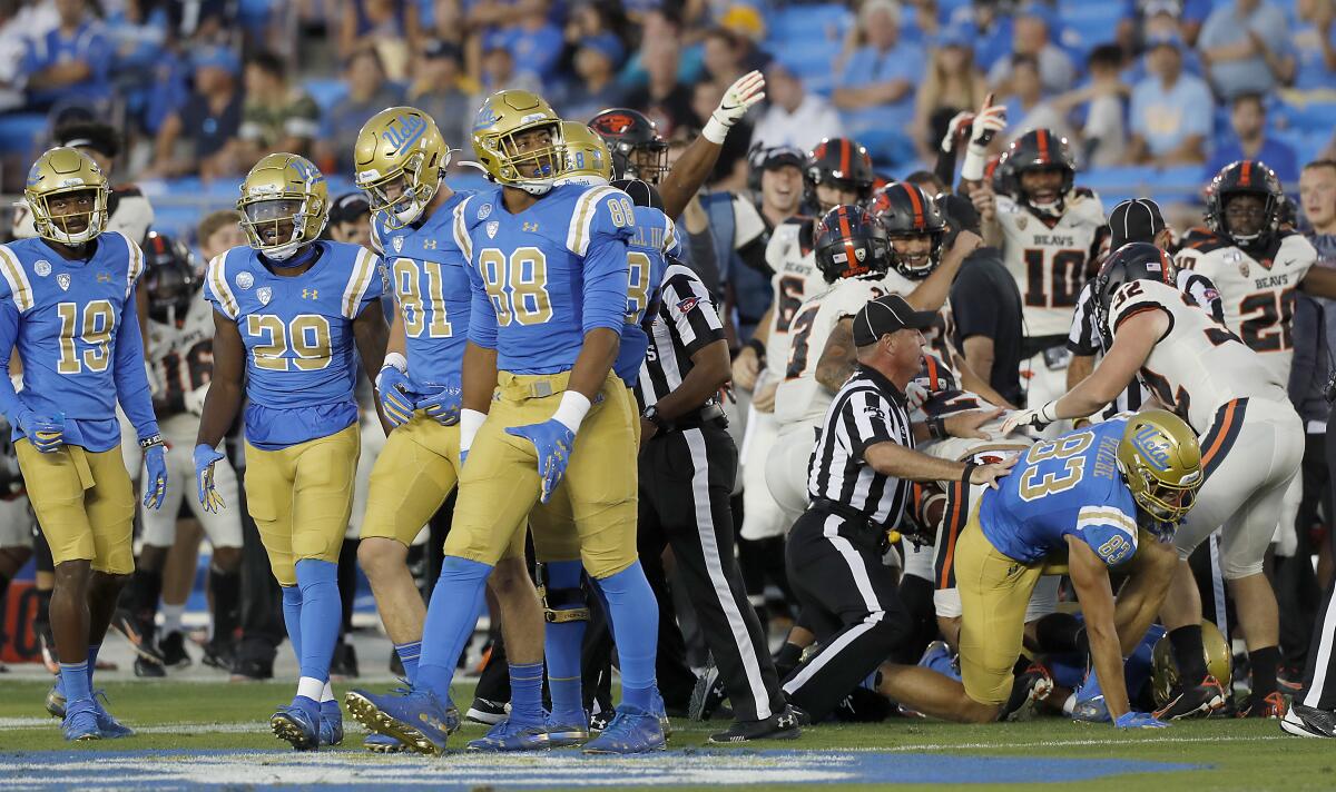 UCLA players walk off the field after Oregon State recovers a fumble on a Bruins kick return during Saturday's game.
