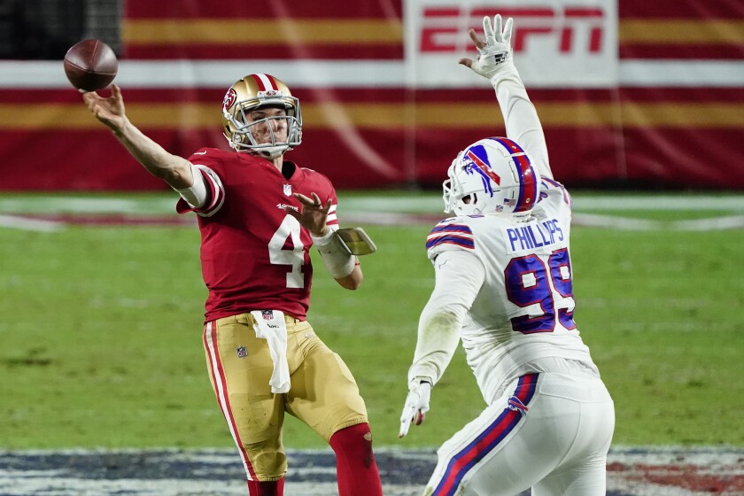 San Francisco 49ers quarterback Nick Mullens (4) throws over Buffalo Bills defensive tackle Harrison Phillips (99) during the second half of an NFL football game, Monday, Dec. 7, 2020, in Glendale, Ariz. The Bills won 34-24. (AP Photo/Rick Scuteri)