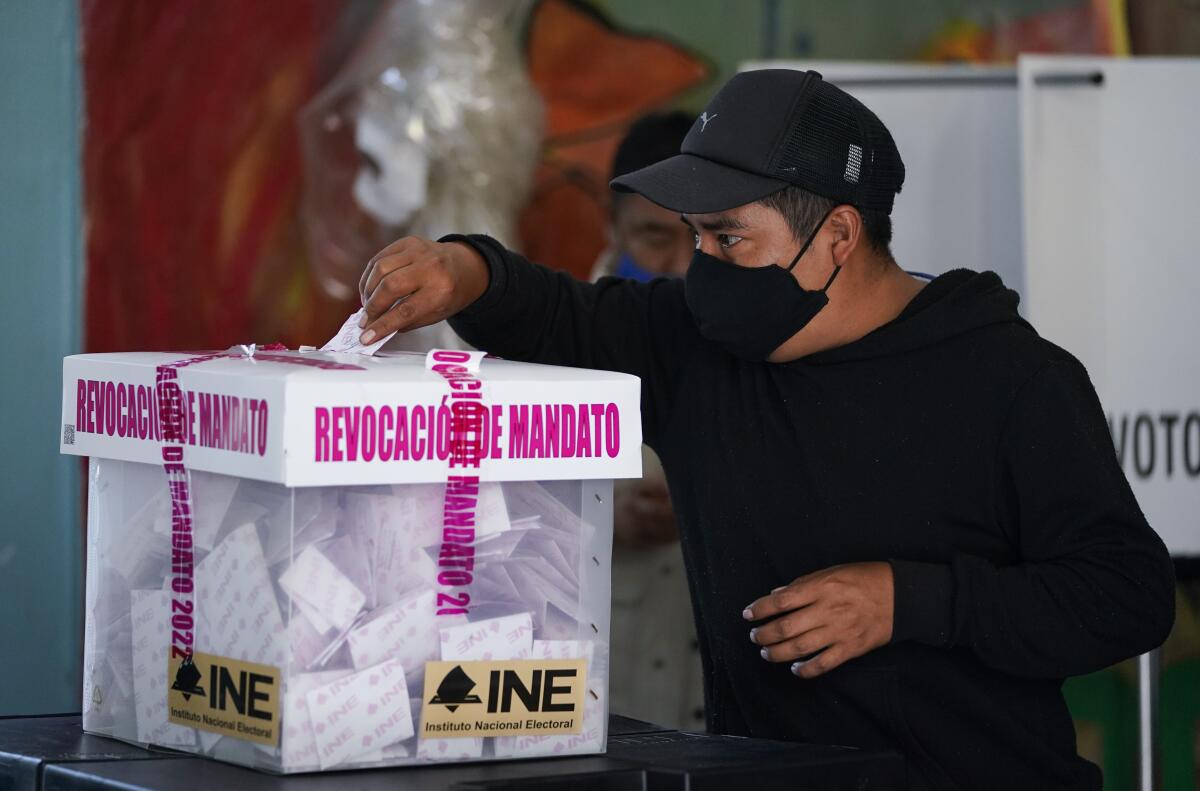 Un hombre emite su voto durante un referendo nacional sobre si el presidente de México