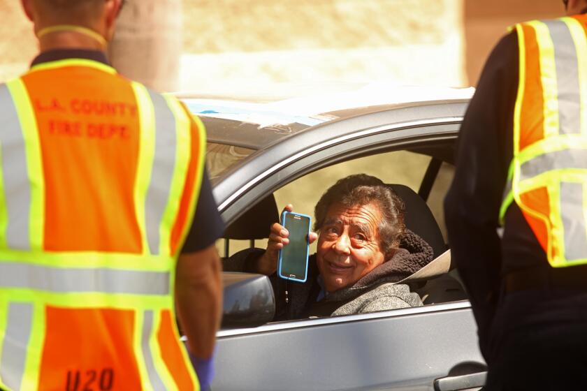 REDONDO BEACH, CA - APRIL 3, 2020 - A woman shows her notice from her doctor that allows her to obtain a test for COVID-19 at a new drive-up testing site in a parking lot at the South Bay Galleria in Redondo Beach on April 3, 2020. This was one of three drive-up testing sites for the new coronavirus in Los Angeles County. The other two sites were opened in Pomona and Palmdale. (Genaro Molina / Los Angeles Times)