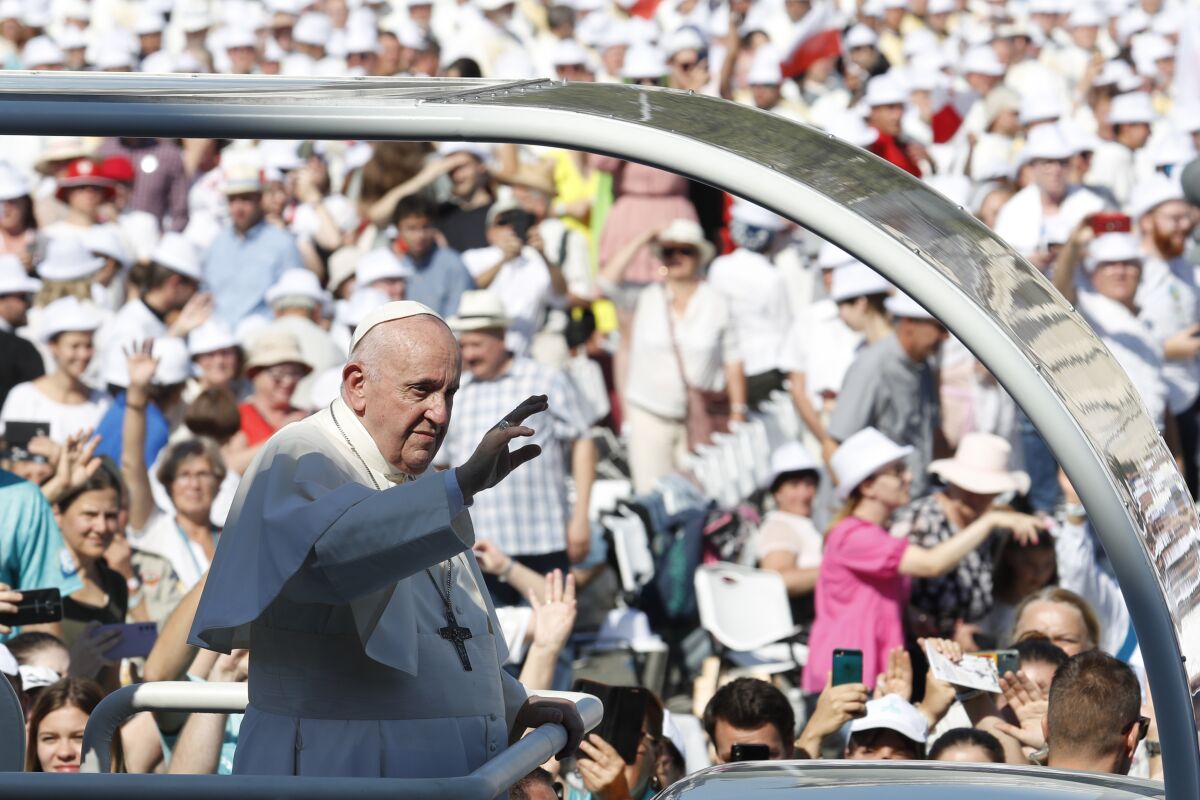 Pope Francis waves to crowds from his vehicle