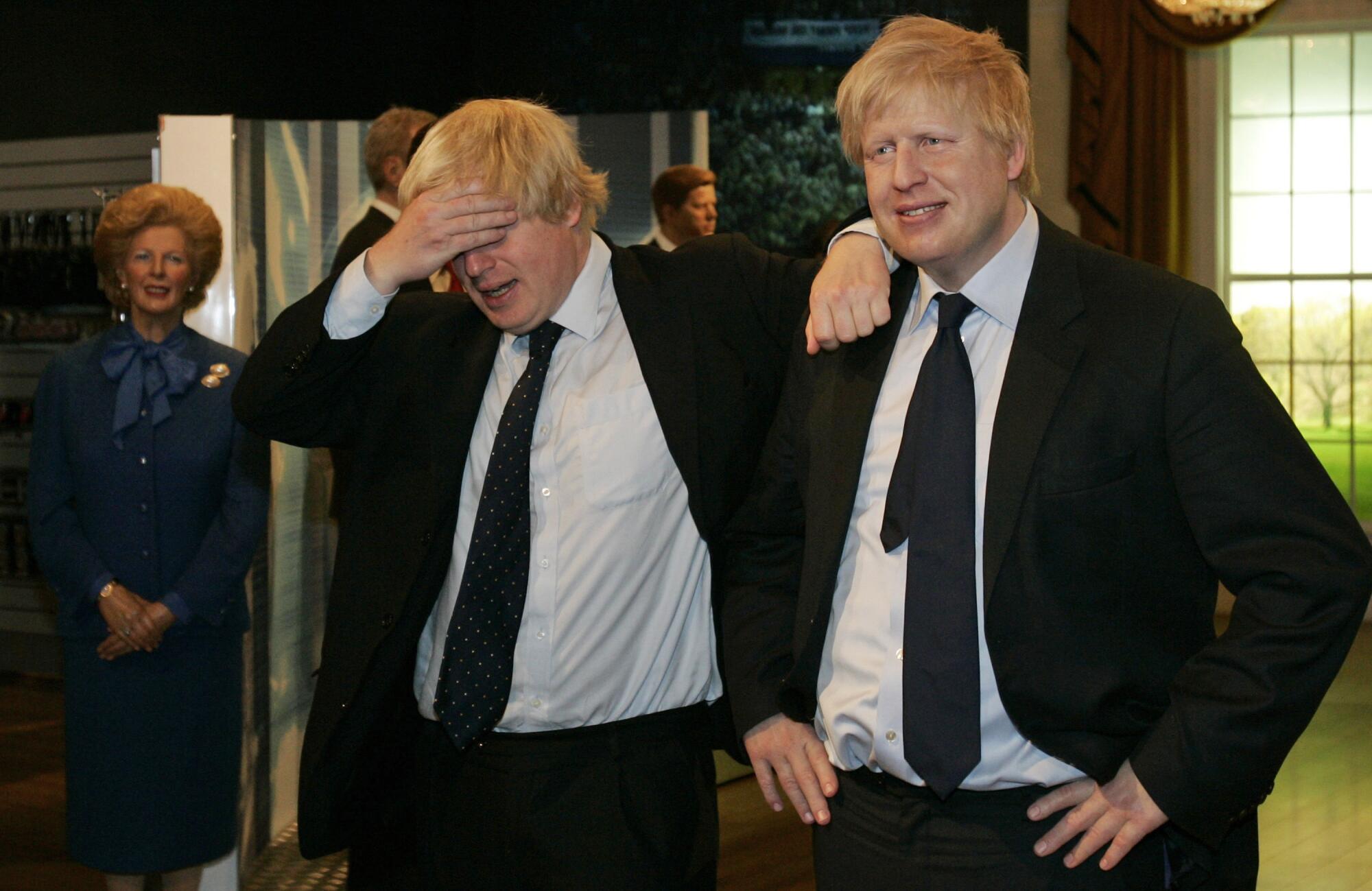 Then-Mayor Boris Johnson, left, poses with a wax figure of himself at Madame Tussauds wax museum in London in 2009.