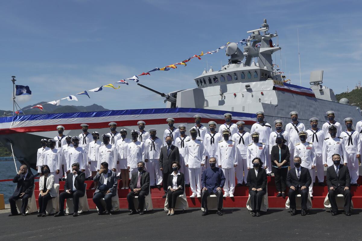 Taiwan's President Tsai Ing-wen, third from right, takes group photo with officers during the commissioning ceremony of the the domestically made Ta Jiang warship at the Suao naval base in Yilan county, Taiwan, Thursday, Sept. 9, 2021. Taiwan's president oversaw the commissioning of the new domestically made navy warship Thursday as part of the island's plan to boost indigenous defense capacity amid heightened tensions with China. (AP Photo/Chiang Ying-ying)
