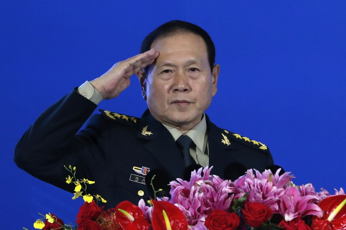 FILE - Chinese Defense Minister Wei Fenghe salutes after delivering his opening speech for the Xiangshan Forum, a gathering of the region's security officials, in Beijing, Monday, Oct. 21, 2019. China's defense minister complained to his American counterpart on Friday, June 10, 2022 about the latest U.S. arms package for Taiwan and warned of a possible conflict over the self—governing island that China claims as its own territory. (AP Photo/Andy Wong, File)