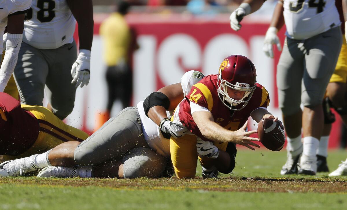 Running a quarterback keeper, USC's Sam Darnold (14) stretches as he is brought down by Colorado defensive end Jordan Carrell in the first half Saturday.