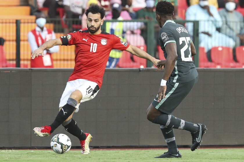 Egypt's Mohamed Salah in action in front of Nigeria's Kenneth Omeruo during the African Cup of Nations Group D soccer match between Egypt and Nigeria in Garoua, Cameroon, Tuesday, Jan. 11, 2022. (AP Photo/Footografiia)