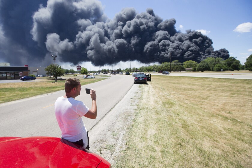 Jeff Phillips watches black smoke cloud billowing over Nazarene Drive Monday, June 14, 2021, in South Beloit, from the massive industrial fire at Chemtool on Prairie Hill Road in Rockton, Ill. (Scott P. Yates/Rockford Register Star via AP)