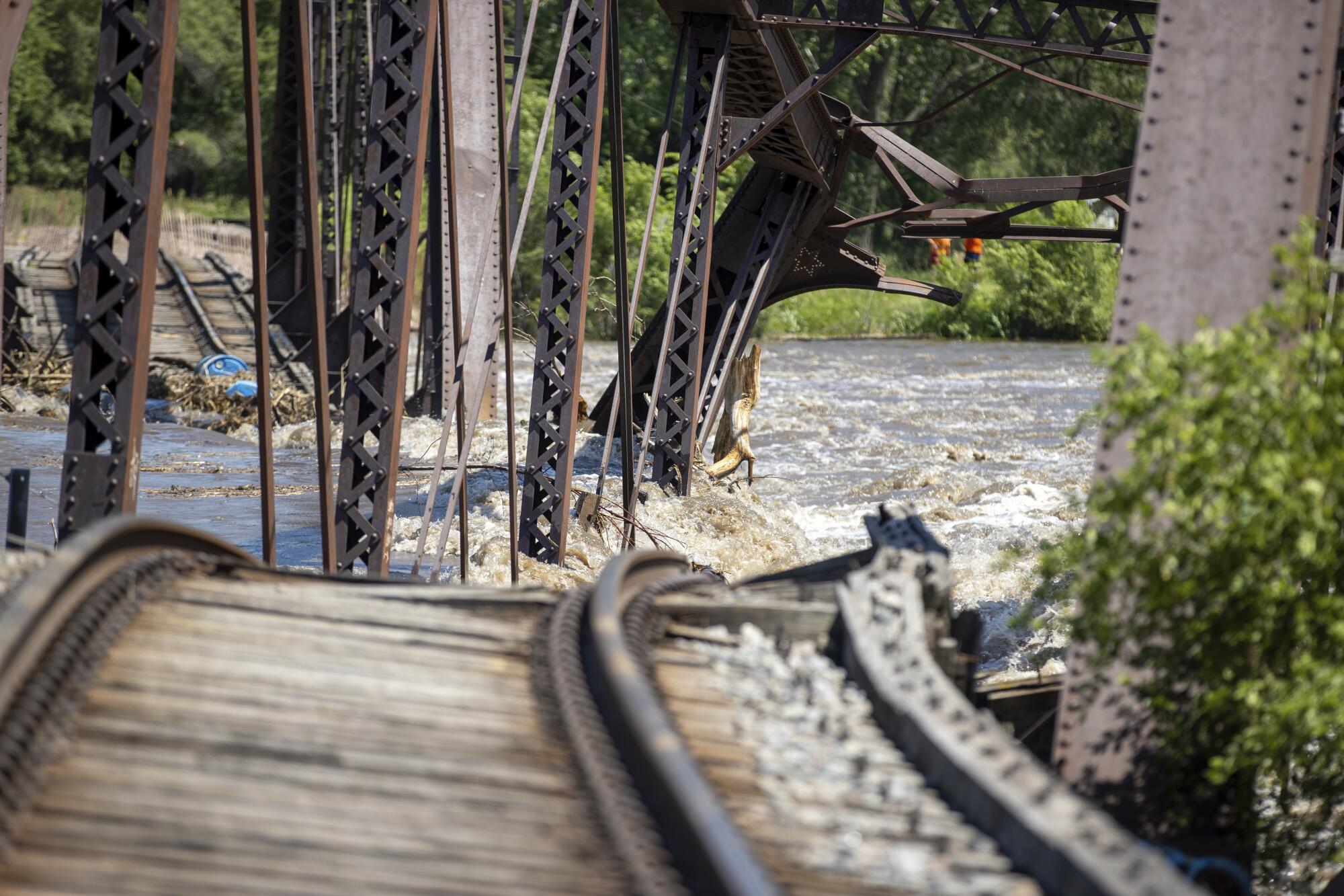 A collapsed bridge lies in a river