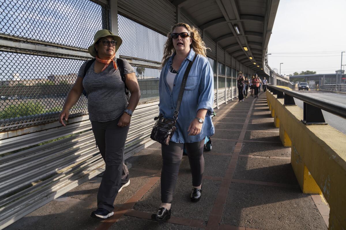 Volunteer lawyers Lillian G. Gonzalez, left, and Jodi Goodwin walk to Matamoros to hold a workshop for asylum seekers who have been sent back to wait in Mexico for their asylum claim under the Trump administration's "Remain in Mexico" policy.
