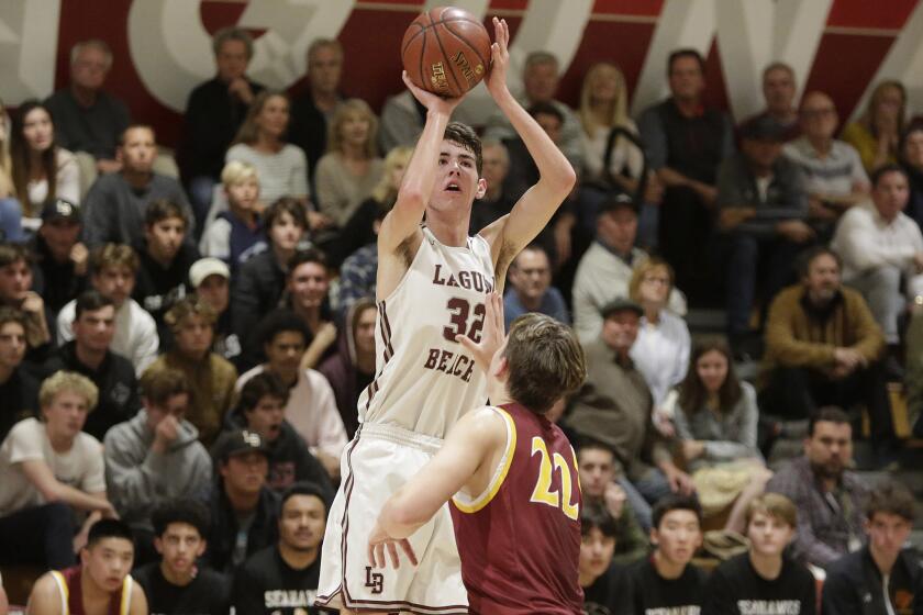 Nolan Naess of Laguna Beach shoots a jumper as Ocean View’s Slater Miller defends during first round of the CIF Southern Section Division 3AA playoffs on Wednesday.