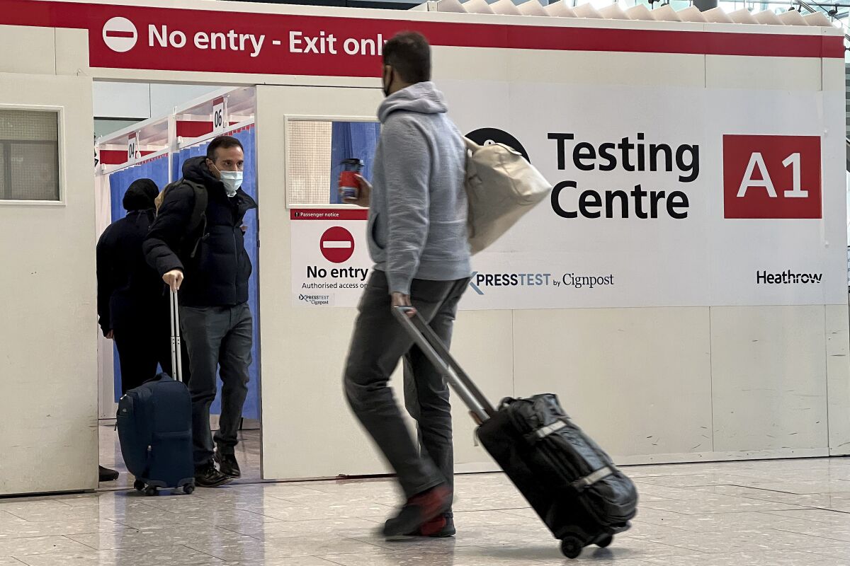 FILE - Passengers get a COVID-19 test at Heathrow Airport in London, Monday, Nov. 29, 2021. Airline and tourism groups are pushing to eliminate the U.S. government requirement that international travelers provide a negative test for COVID-19 before boarding a U.S.-bound plane. Airlines for America, a trade group for the nation's biggest carriers, was circulating a letter Wednesday, Feb. 2, 2022, among other travel associations to urge the Biden administration to end the testing requirement. (AP Photo/Frank Augstein, File)