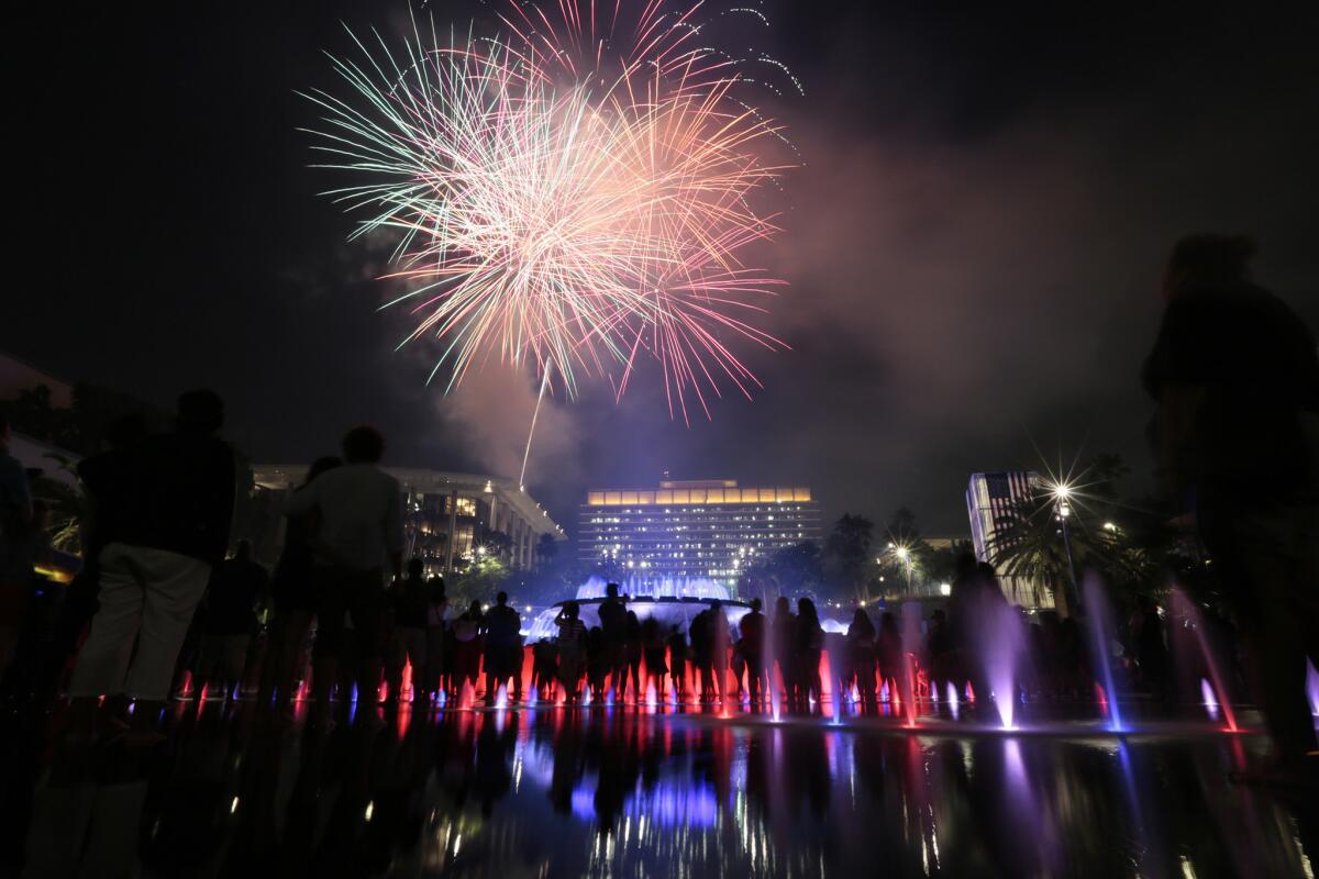Fireworks explode over the Dorothy Chandler Pavilion as tens of thousands of people look on from the Grand Park Fourth of July celebration in downtown Los Angeles.