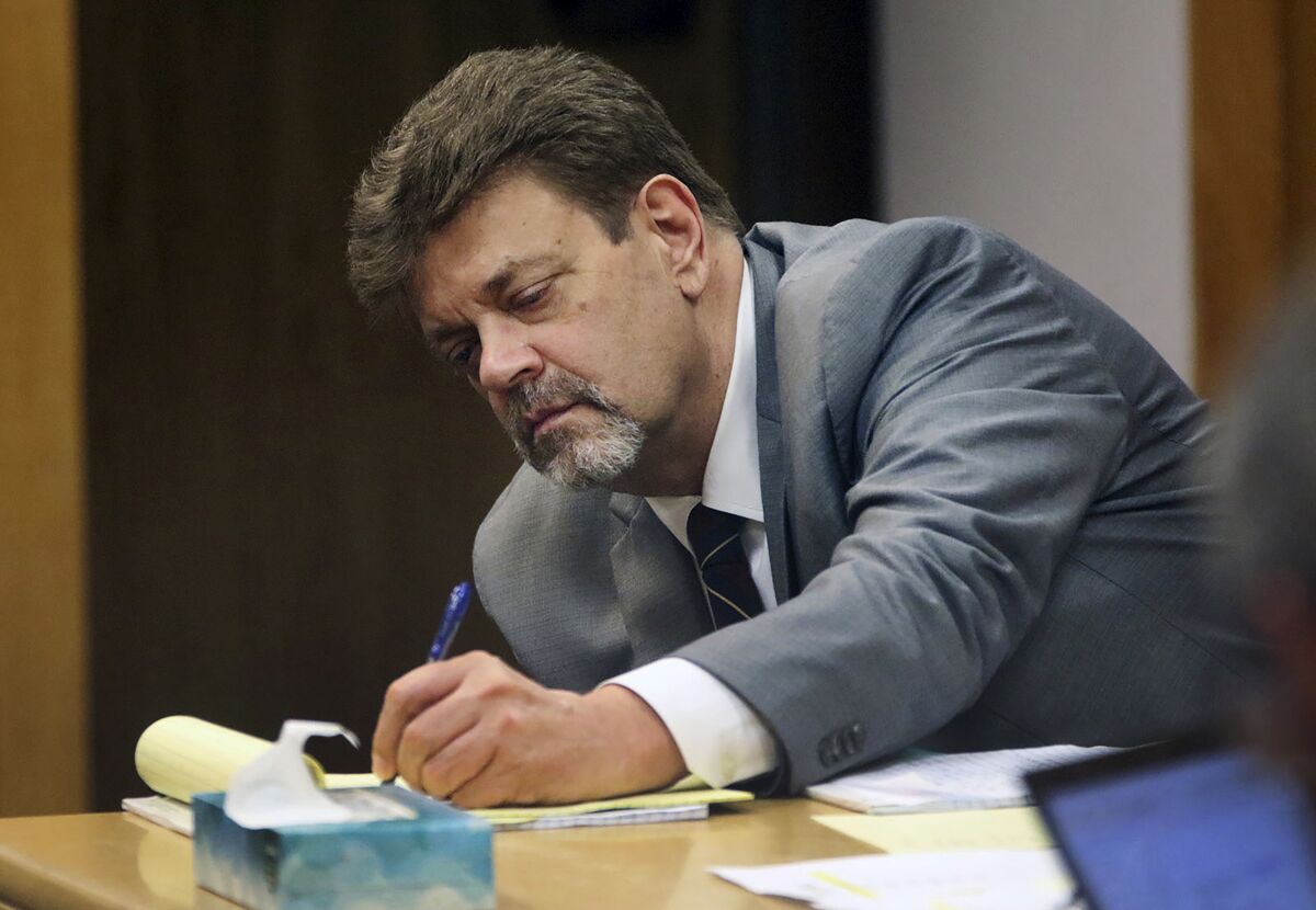 FILE - In this June 29, 2021, file photo, Mark Redwine takes notes as a former sheriff's investigator, testifies during his trial in Durango, Colo. Redwine was sentenced, Friday, Oct. 8, 2021 to 47 years in prison for the 2012 disappearance of his 13-year-old son. The Durango Herald reports that Redwine, 60, was convicted of second-degree murder and child abuse resulting in the death of his son Dylan Redwine. (Jerry McBride/The Durango Herald via AP, File)