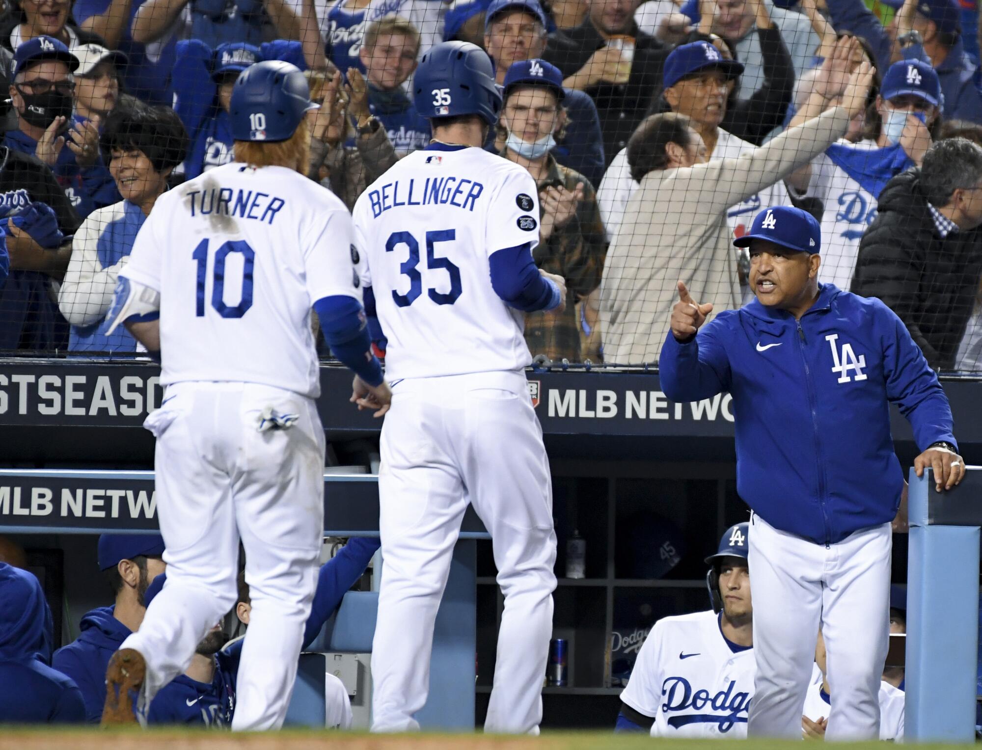 Dodgers manager Dave Roberts celebrates after Cody Bellinger and Justin Turner scored.