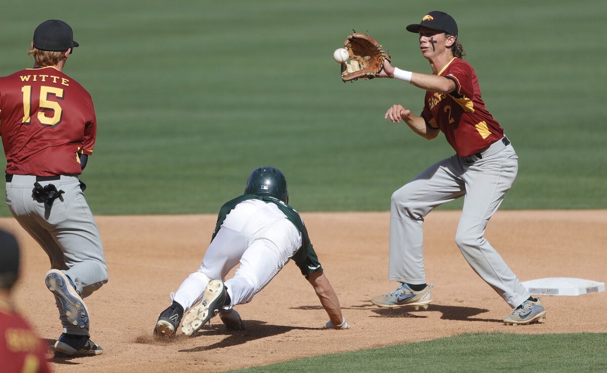 Costa Mesa's Chris Hall is stuck in a rundown between Estancia's Riley Witte (15) and Andrew Mits (2) on Monday.