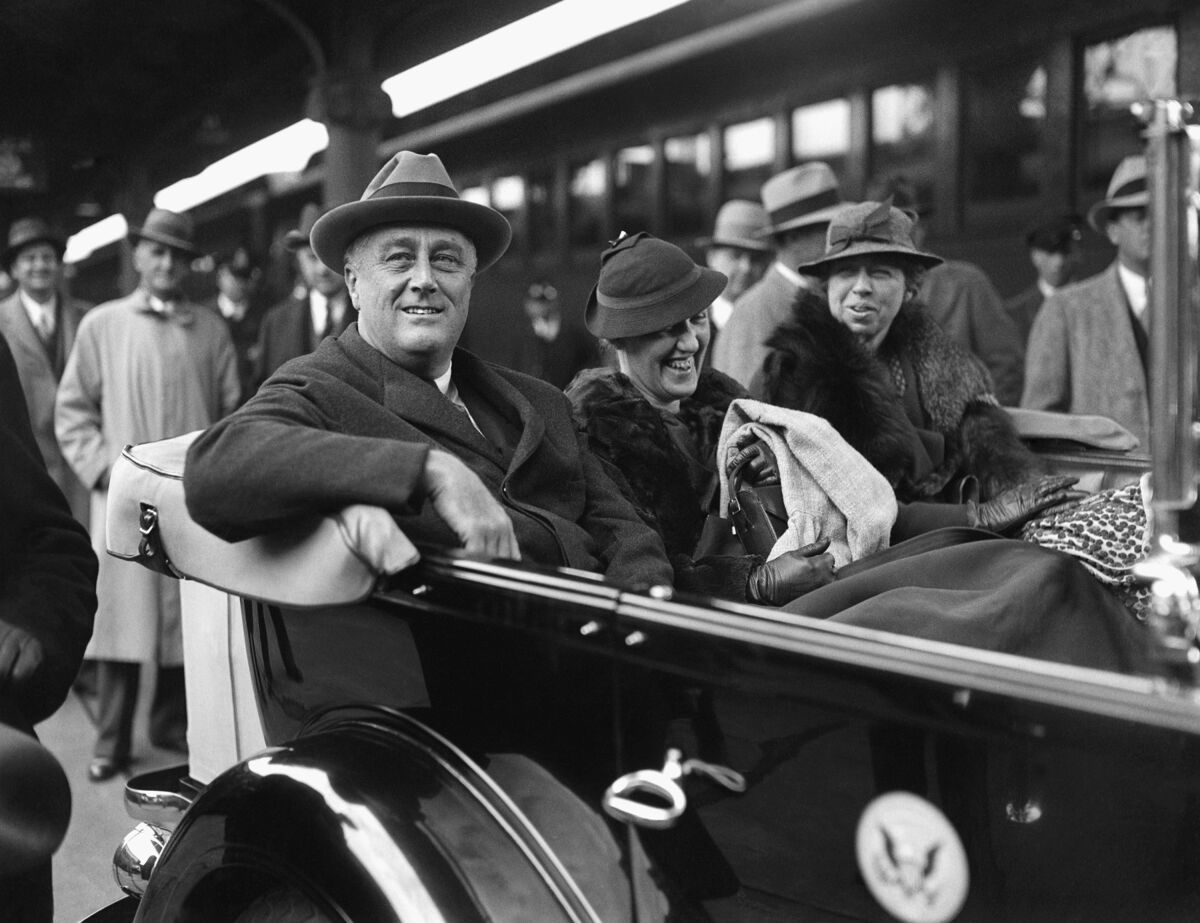 President Franklin D. Roosevelt, from left, secretary Marguerite LeHand and First Lady Eleanor Roosevelt ride in a car.