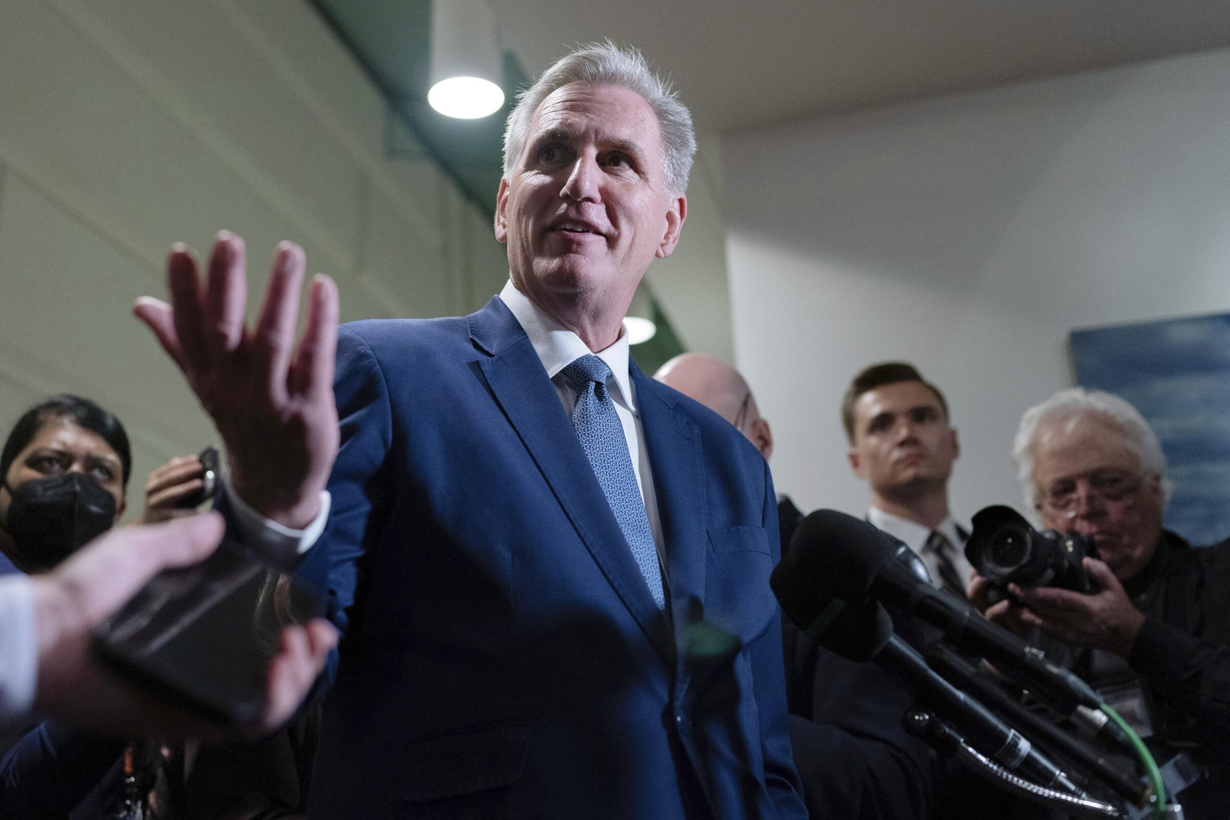 A man in a suit speaks to reporters.