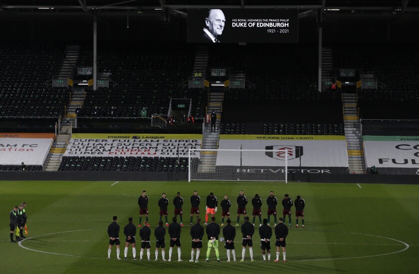 Players from both sides observe a minute's silence to honor Britain's Prince Philip, Duke of Edinburgh, after the announcement of the death today, before the English Premier League soccer match between Fulham and Wolverhampton Wanderers at Craven Cottage stadium in London, England, Friday, April 9, 2021.(Andrew Couldridge/Pool via AP)
