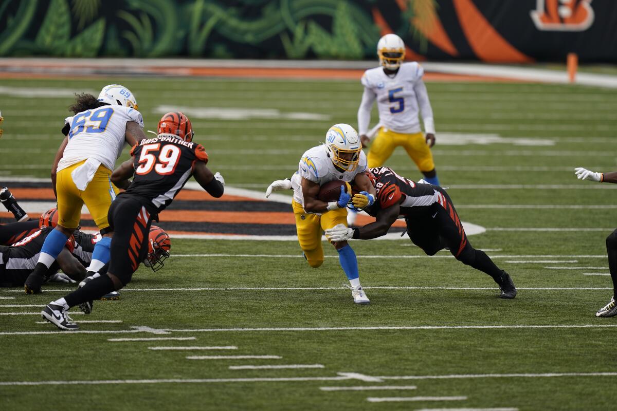 Chargers' Austin Ekeler is tackled by Cincinnati Bengals' Carl Lawson.