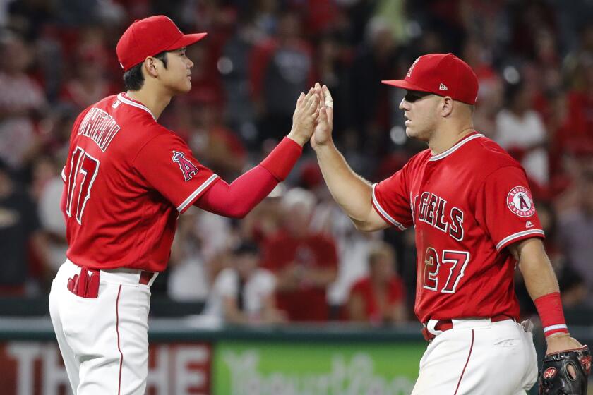 Los Angeles Angels' Shohei Ohtani, left, of Japan, and Mike Trout celebrate the team's 11-2 win.