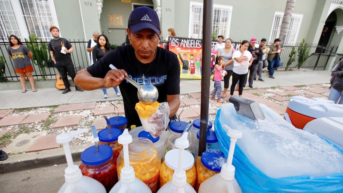 HOLLYWOOD CA JULY 25, 2017 -- Street cart vendor Alex Ramirez serves up ice and fruit in Hollywood, close to the area where his son, Benjamin Ramirez, had his cart overturned after a dispute with another individual. Approximately 30 supporters have arrived near the location where the confrontation took place. (Francine Orr/ Los Angeles Times)