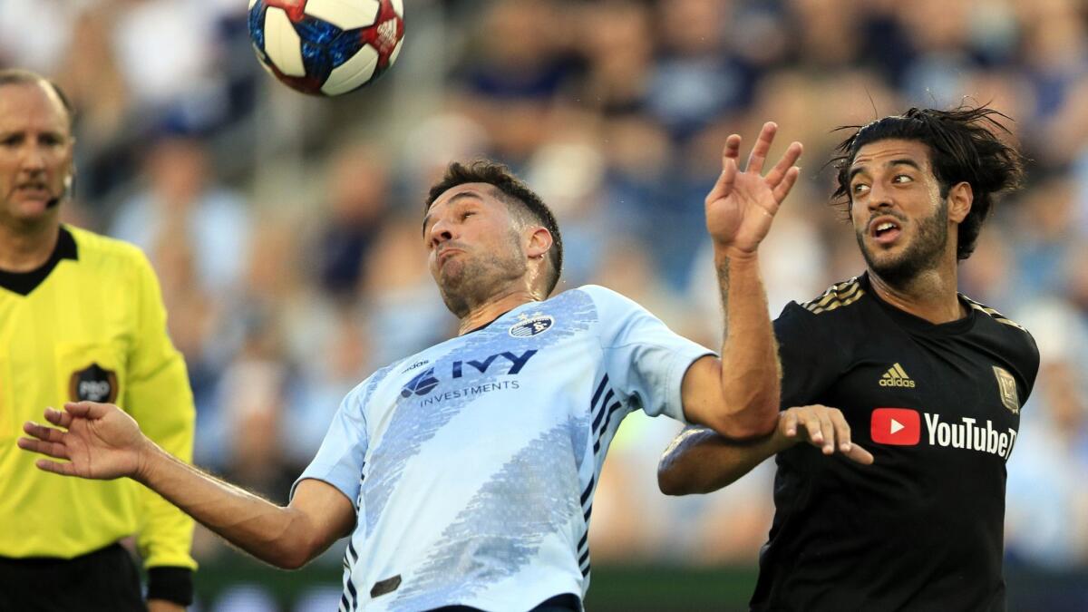 Sporting Kansas City midfielder Benny Feilhaber, left, keeps the ball from LAFC forward Carlos Vela, right, during the first half in Kansas City, Kan. on Wednesday.