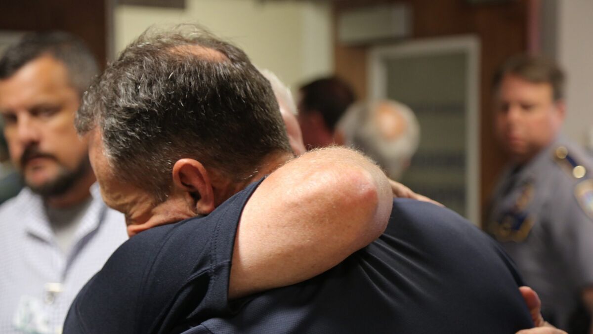 Baton Rouge Police Chief Carl Dabadie gets an emotional hug after a press conference on July 17.
