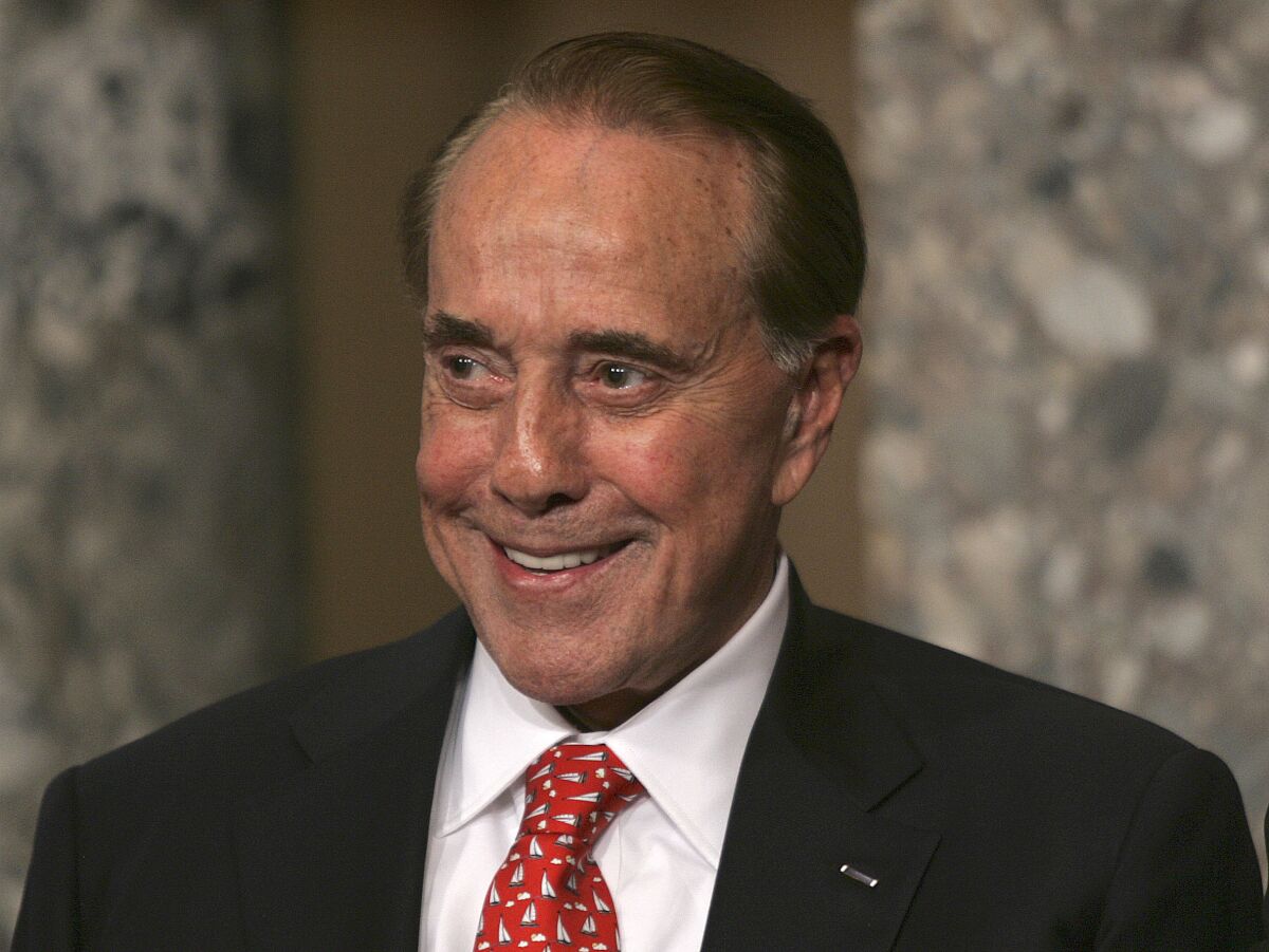 FILE - Former Senate Majority Leader Bob Dole, R-Kan., attends the unveiling of his portrait at the U.S. Capitol, in Washington, July 25, 2006. Bob Dole, who overcame disabling war wounds to become a sharp-tongued Senate leader from Kansas, a Republican presidential candidate and then a symbol and celebrant of his dwindling generation of World War II veterans, has died. He was 98. His wife, Elizabeth Dole, posted the announcement Sunday, Dec. 5, 2021, on Twitter. (AP Photo/Lawrence Jackson, File)
