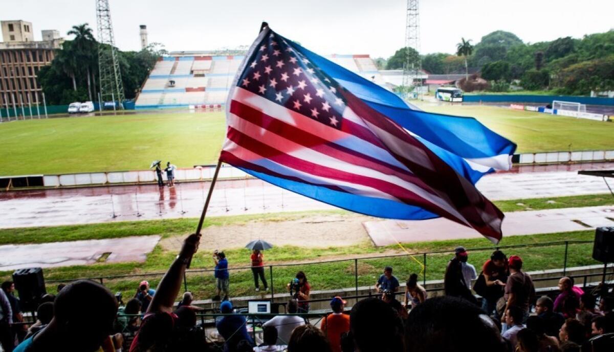 Aficionados cubanos ondean las banderas de EEUU y Cuba durante un partido amistoso de fútbol celebrado en La Habana entre Cuba y los New York Cosmos el 2 de junio de este año.