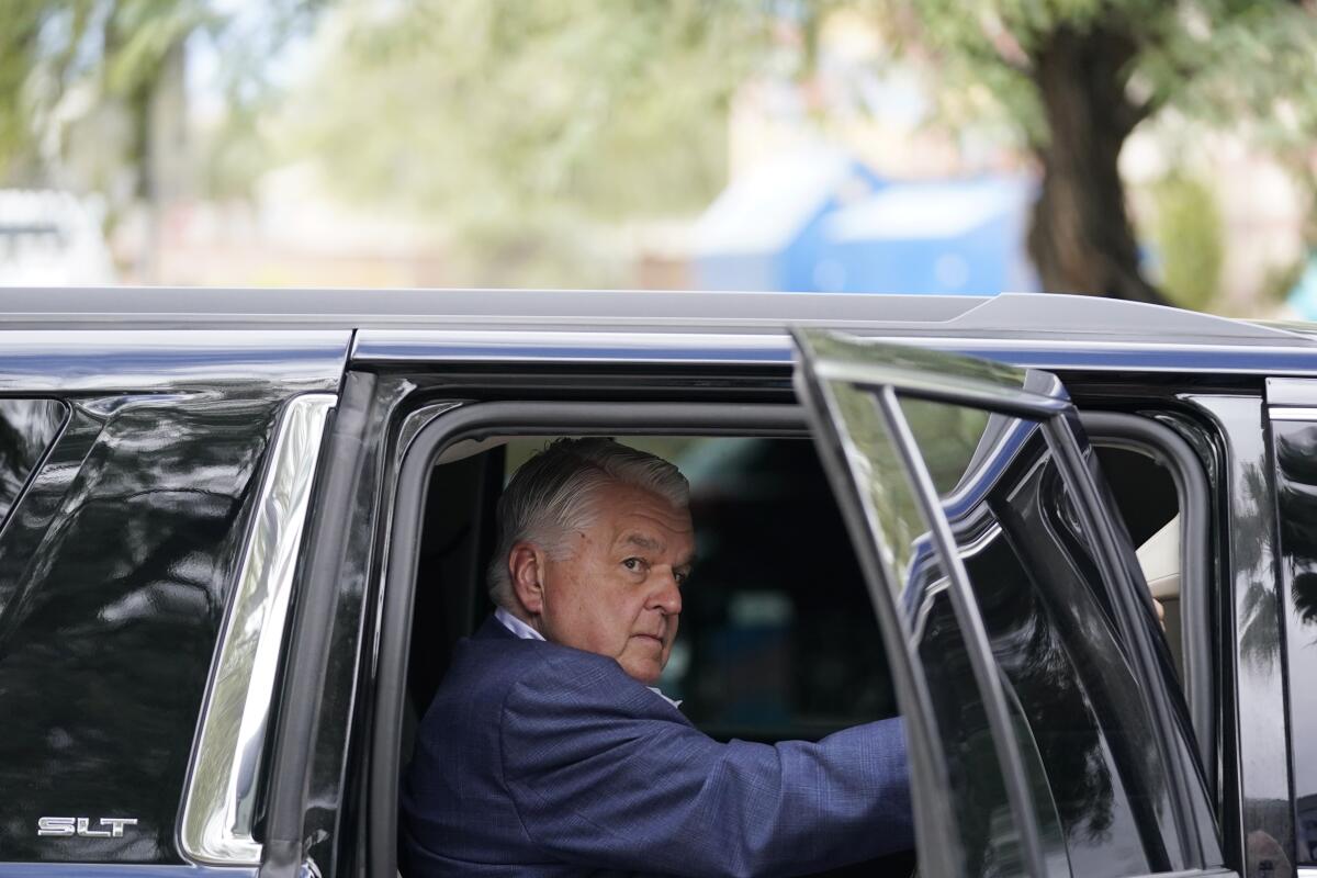 Gov. Steve Sisolak opens a car door.