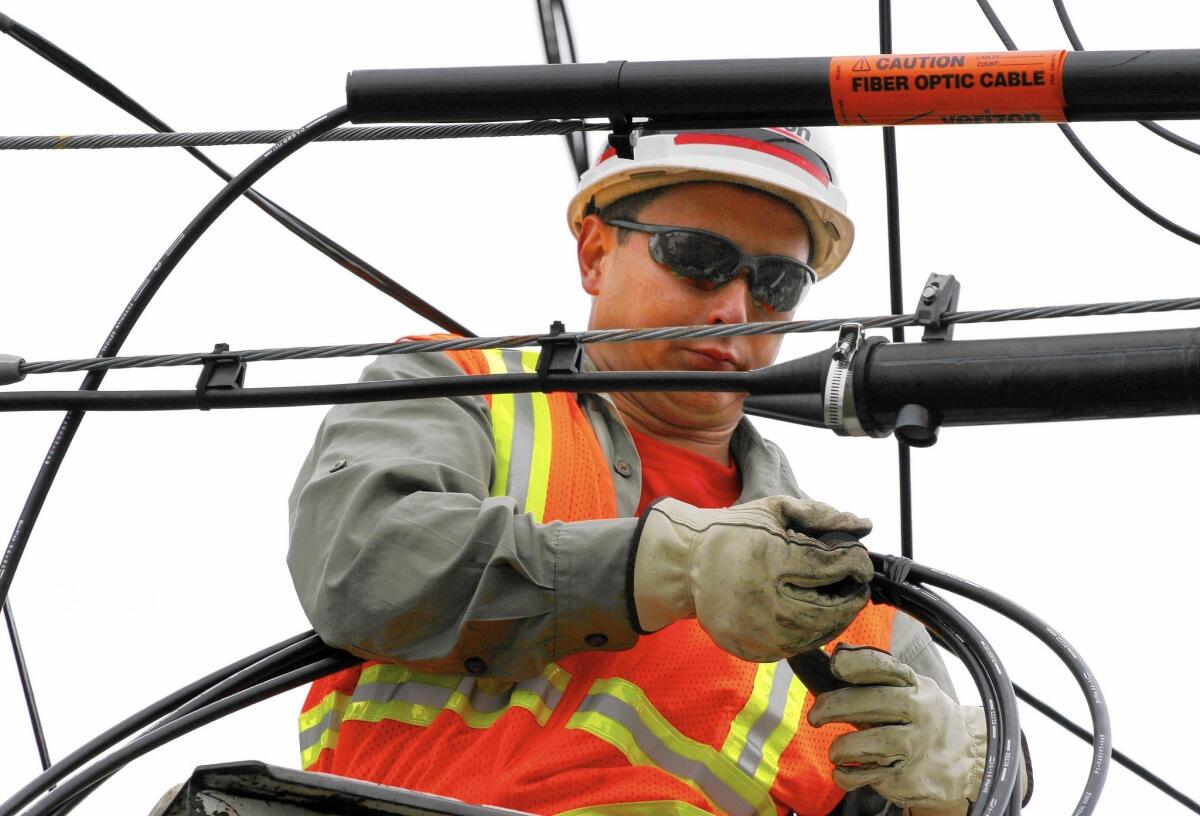 A Verizon lineman installs fiber-optic cable on a telephone pole in Massapequa Park, N.Y., in 2006. Frontier Communications recently acquired Verizon's landline operations, including its FiOS broadband connections, in California.