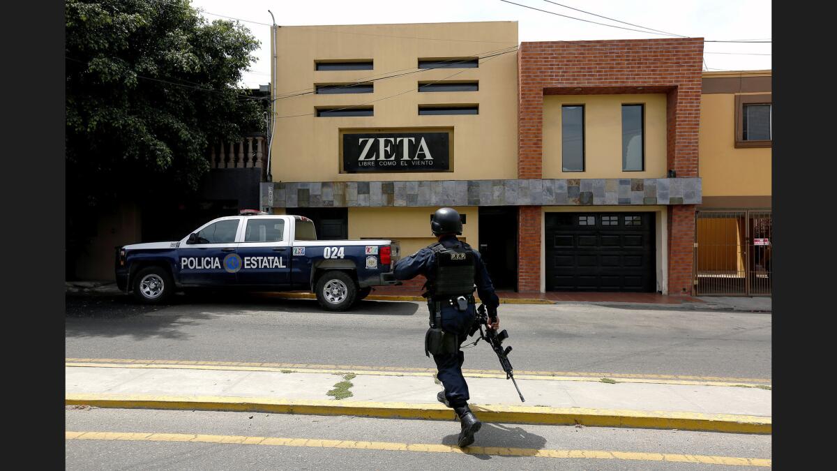 La policía estatal de Baja California monta guardia frente a las oficinas de Zeta, un semanario de investigación que recientemente recibió amenazas de los cárteles mexicanos de la droga, en respuesta a los reportes sobre sus delitos (Gary Coronado / Los Angeles Times).
