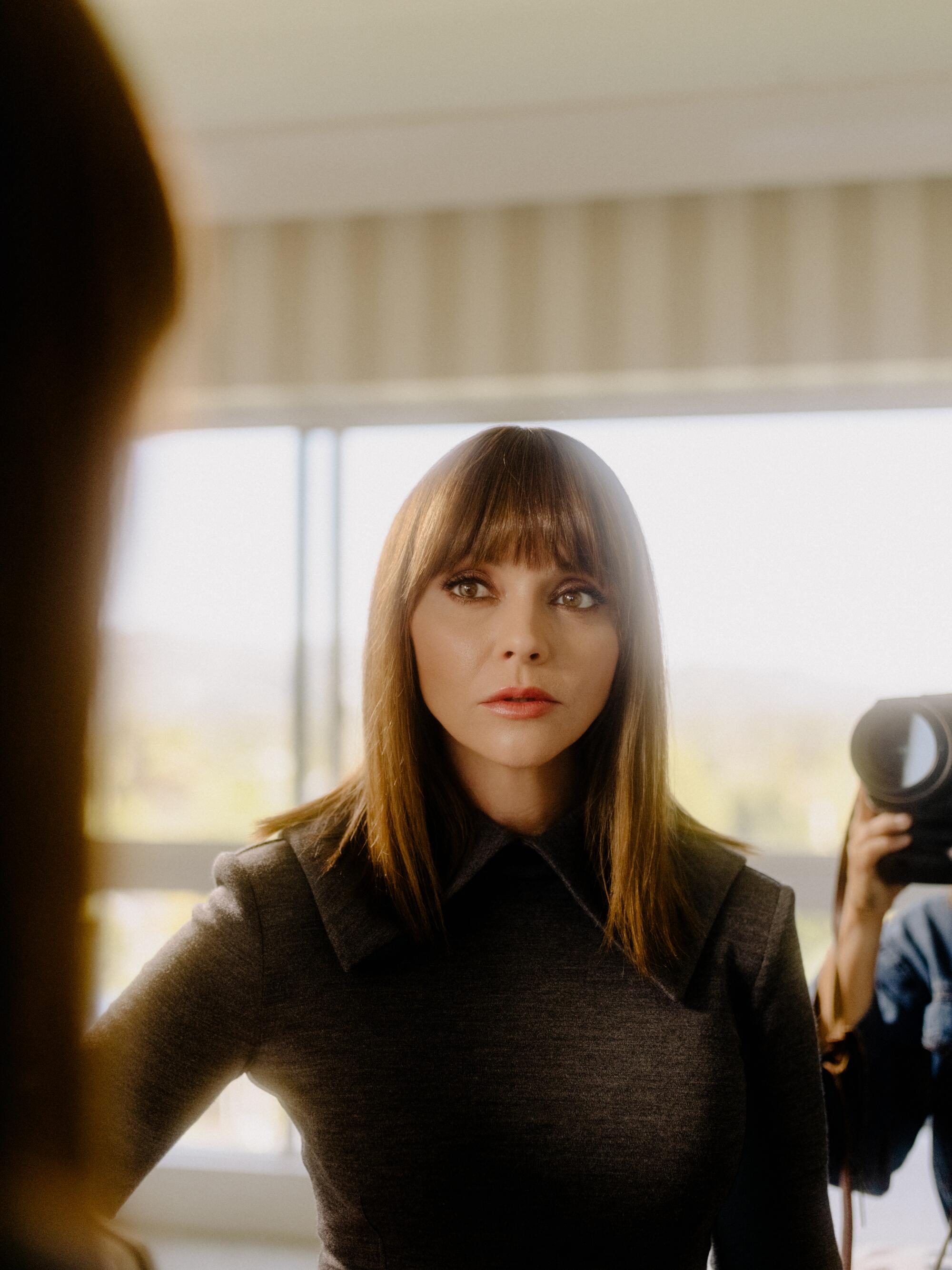 Christina Ricci looks in the mirror at her reflection at the Beverly Hilton.