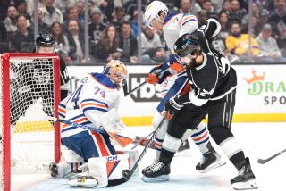 Kings forward Phillip Danault tries to shoot the puck past Edmonton Oilers goaltender Stuart Skinner.