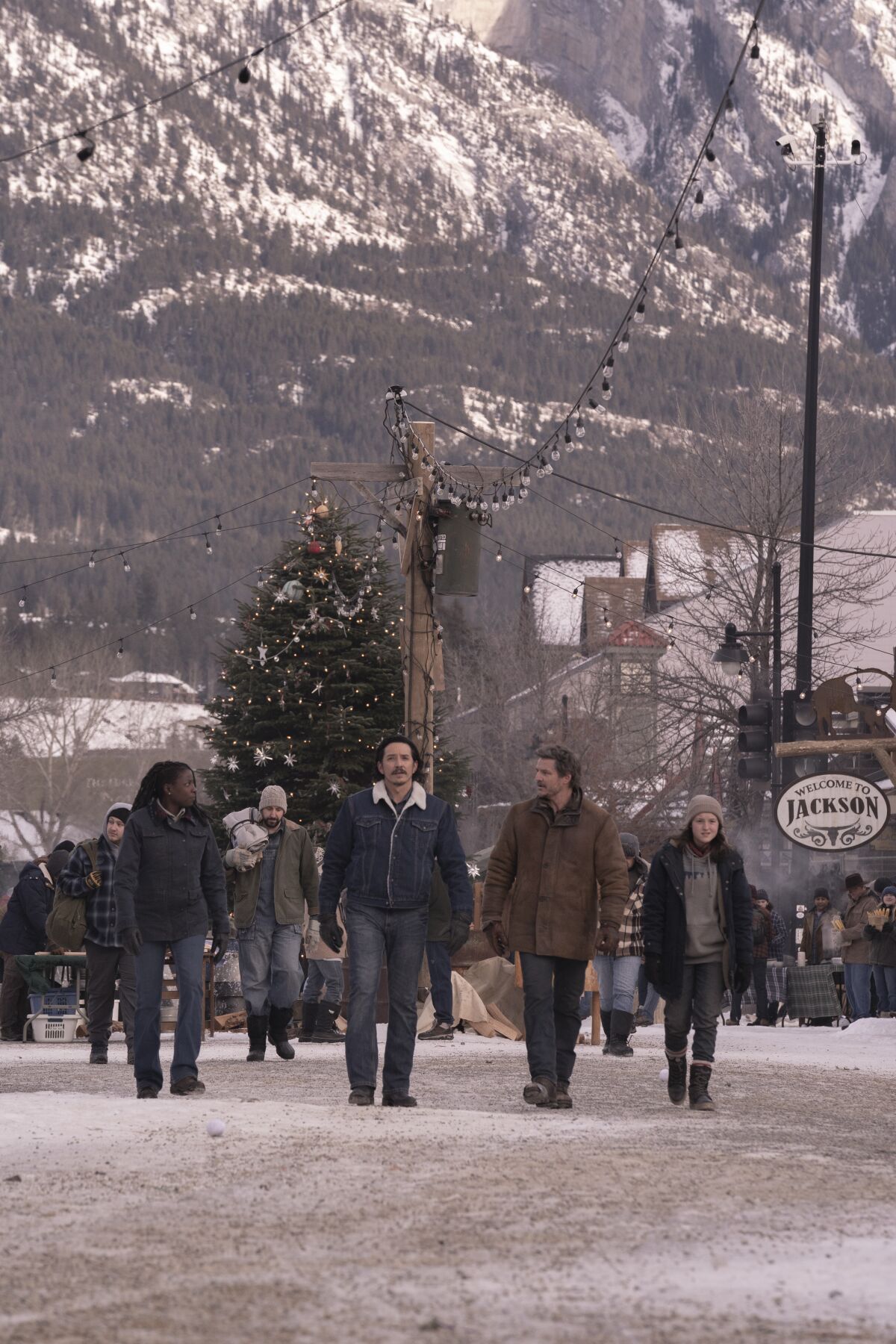 A group of people walk through an Old West-style town
