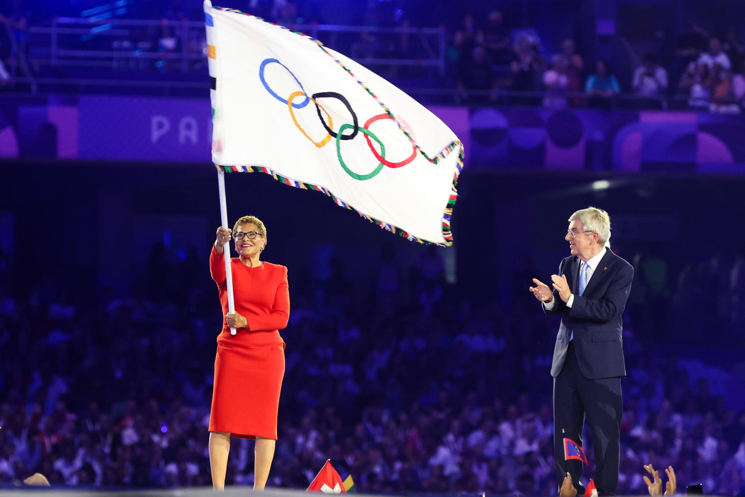 L.A. Mayor Karen Bass holds up the Olympic flag during the closing ceremony of the 2024 Paris Olympics 