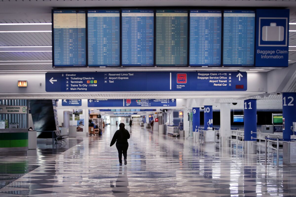 A worker walks through a baggage claim area at a nearly-empty O'Hare International Airport in Chicago.