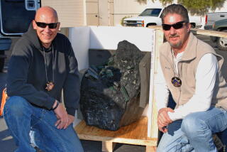 Two men pose beside the Bahia Emerald