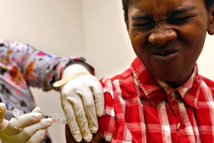 Desmond Sewell, de 12 años, recibe sus vacunas por parte de la asistente médica Jessica Reyes en el Centro de Salud y Bienestar Infantil Lou Colen, en Mar Vista.