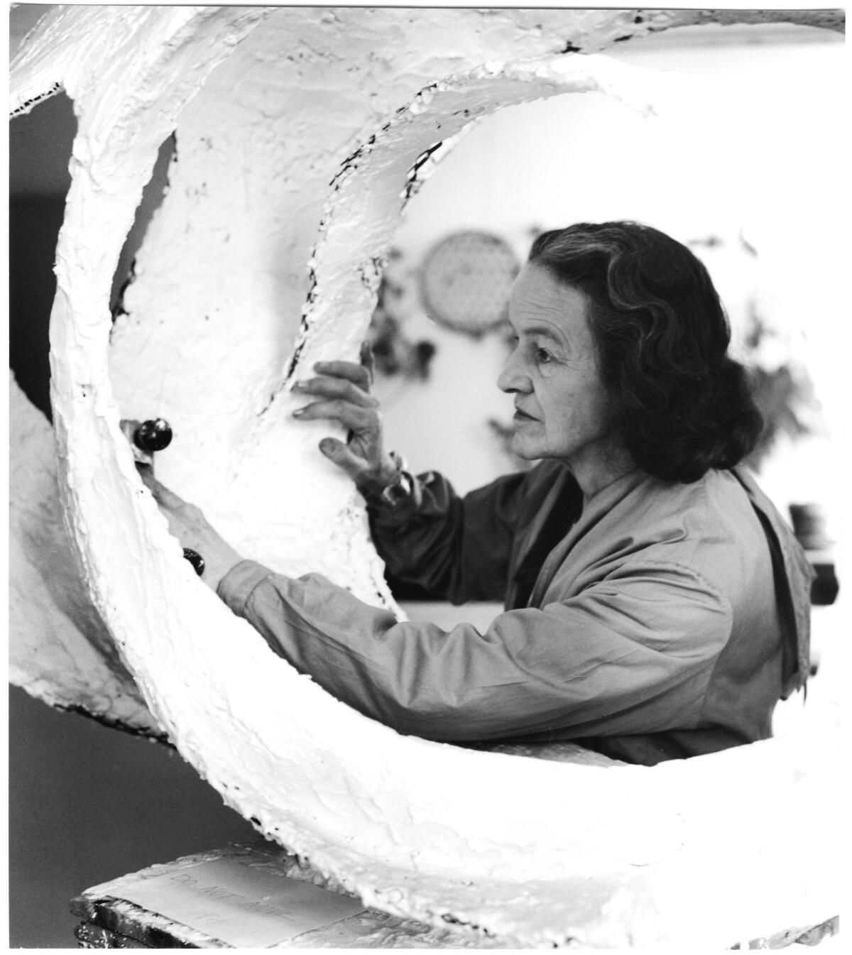Barbara Hepworth at work on the plaster for Oval Form (Trezion), 1963.