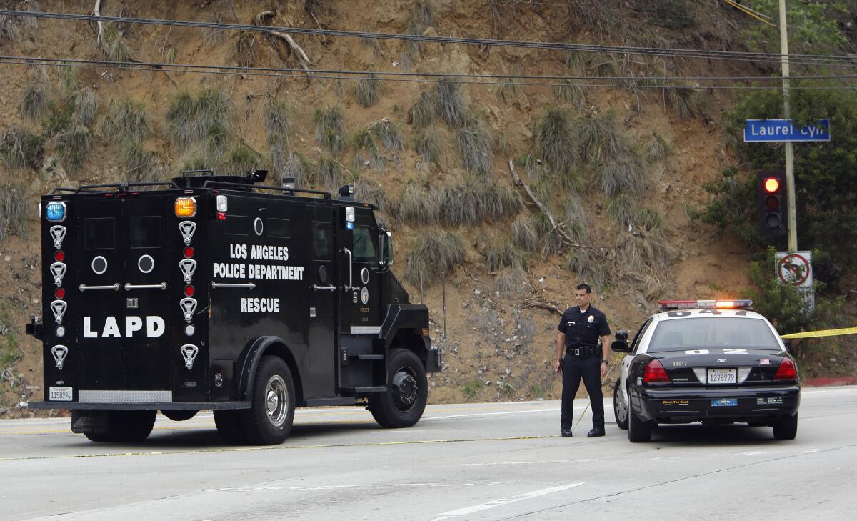 An LAPD rescue vehicle turns onto Laurel Canyon toward a single-family home on Gould Avenue Monday in the Hollywood Hills, where an LAPD officer was injured when officers responded to a domestic violence call.