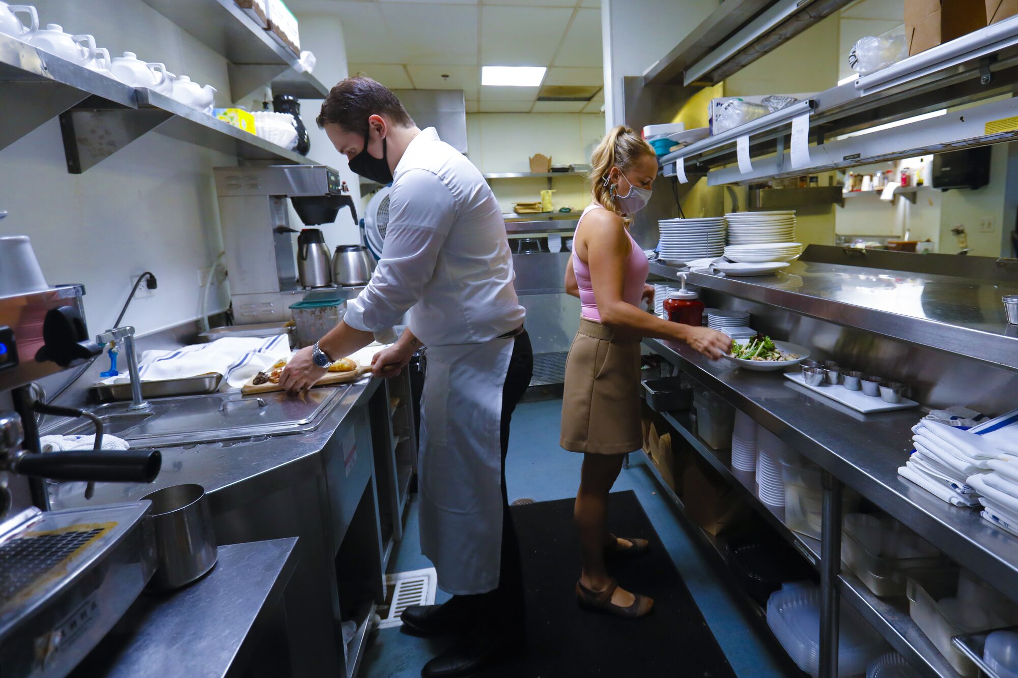 Kyle Burke and Samantha Scholl put the last touches on entrees to be taken to customers.